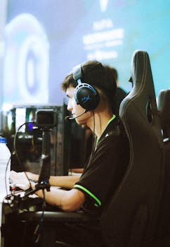 Side view of a focused gamer wearing a headset during a gaming tournament.
